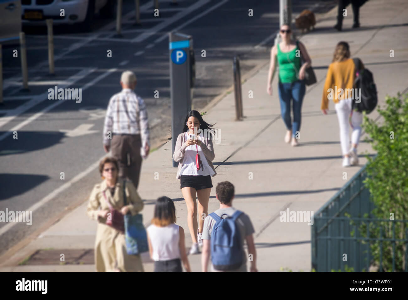 Eine Frau geht durch Ninth Avenue im Stadtteil Chelsea in New York abgelenkt von ihrem Smartphone auf Freitag, 10. Juni 2016. (© Richard B. Levine) Stockfoto
