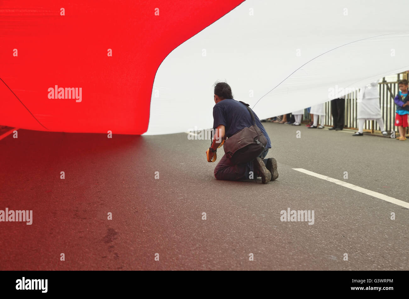 Jakarta, Indonesien. 21. Februar 2015. Ein Journalist/Fotograf unter die rote & White indonesische Flagge Stockfoto