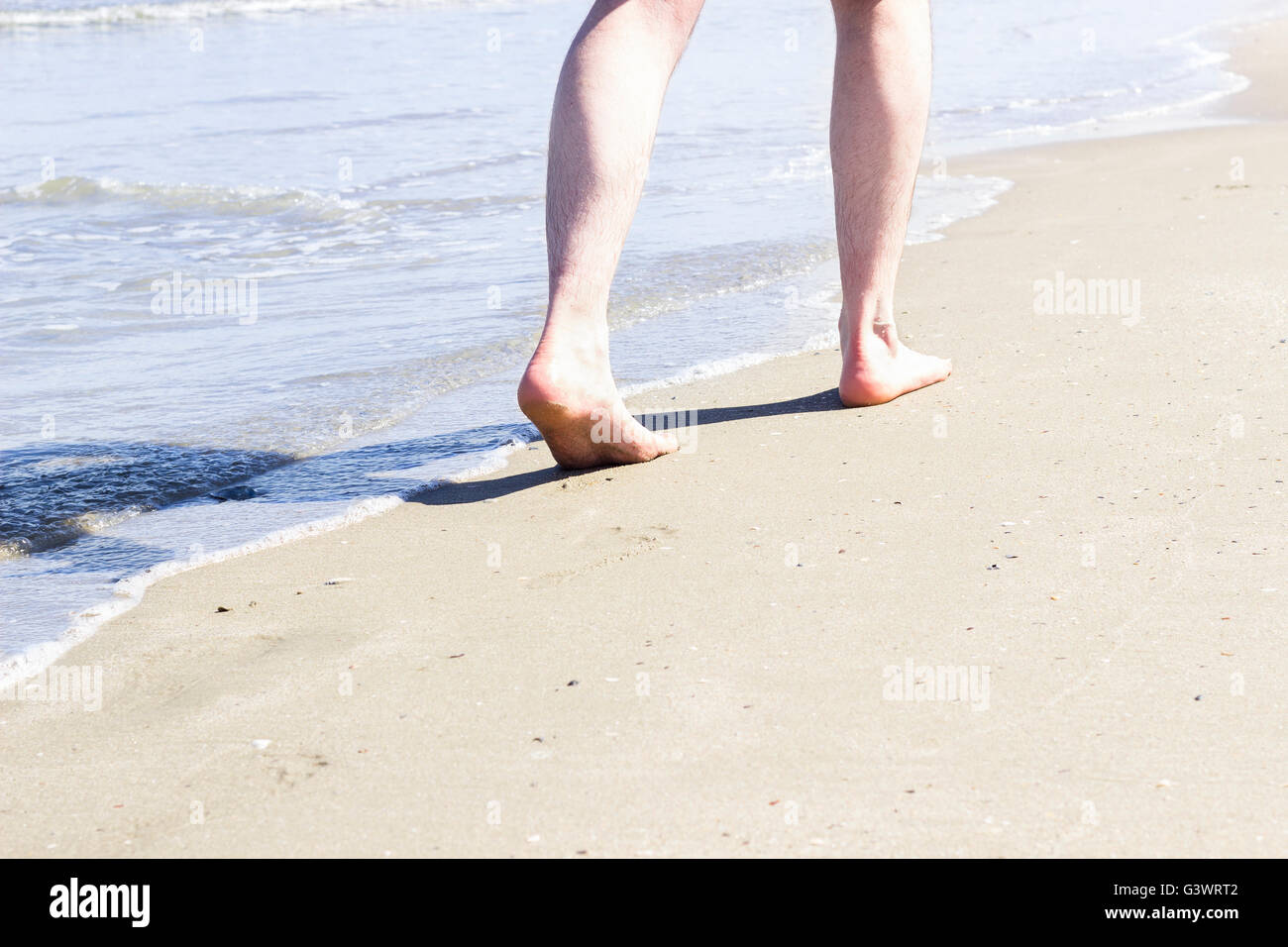 Einzigen Mann zu Fuß am Strand. Stockfoto