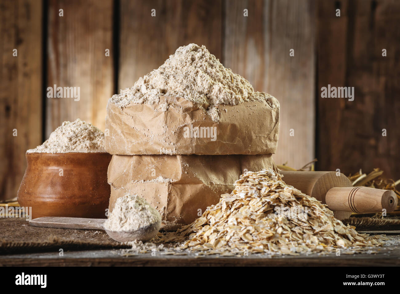 Vollkorn Haferflocken Mehl und Hafer, Nudelholz, Löffel auf den alten hölzernen Hintergrund closeup Stockfoto