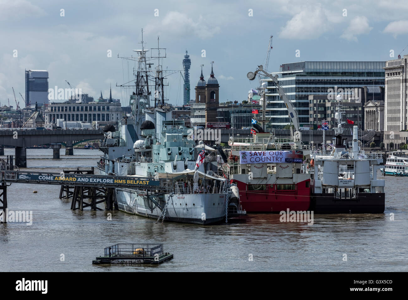 HMS Belfast und Angelboote/Fischerboote auf der Themse mit London Bridge in der Ferne Stockfoto