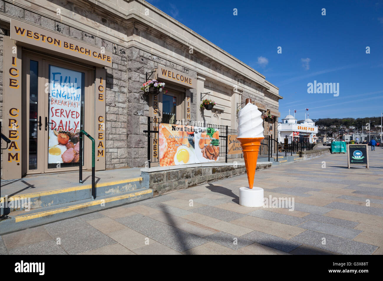 Ein Riesen Eistüte steht vor dem Hintergrund der Werbung am Strand von Weston-Super-Mare. Stockfoto