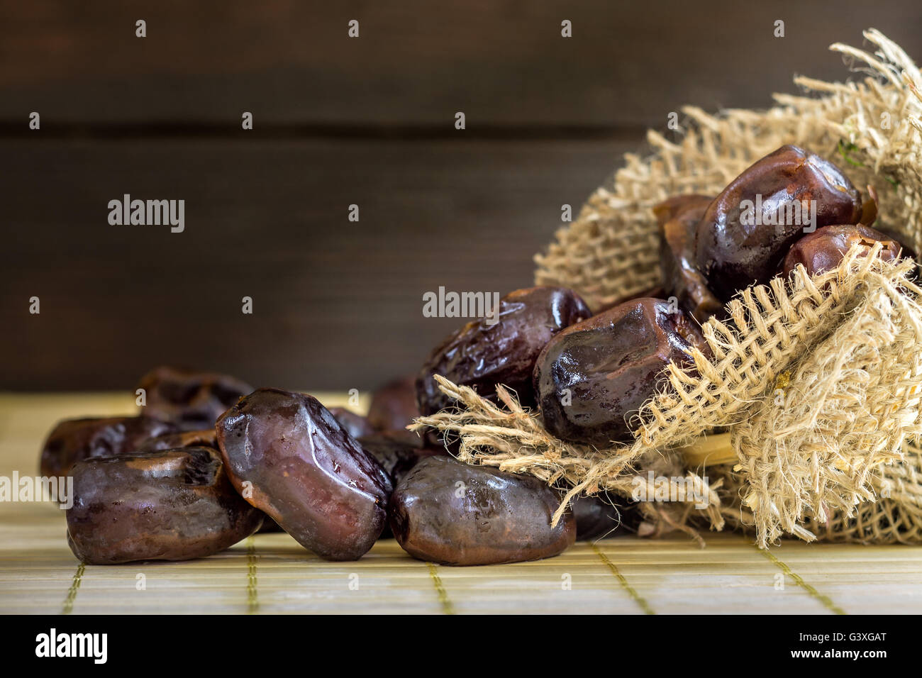 Termine auf hölzernen Hintergrund aus Jute-Tasche. Viele Textfreiraum Stockfoto