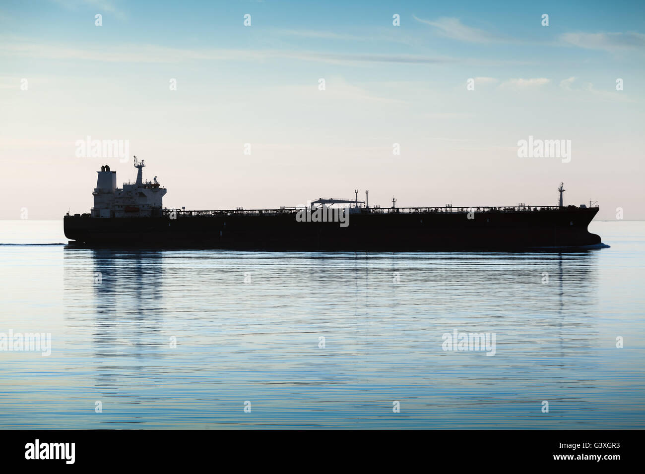 Große industrielle Tanker Schiff geht auf noch Meerwasser, Silhouette Foto, natürlichen Gegenlicht Effekt Stockfoto