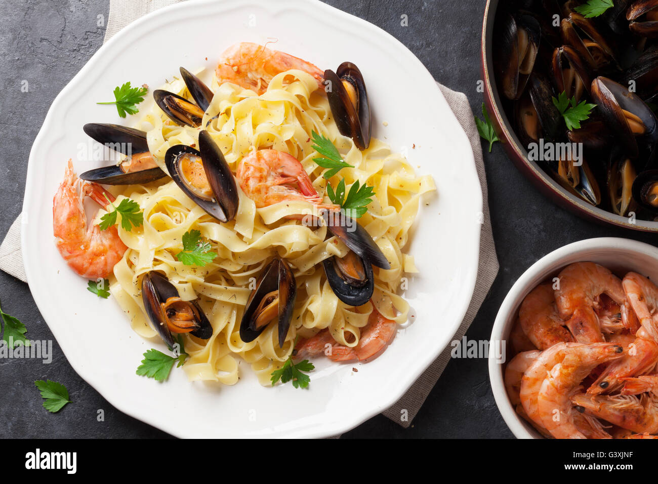 Pasta mit Meeresfrüchten am Steintisch. Muscheln und Garnelen. Ansicht von oben Stockfoto