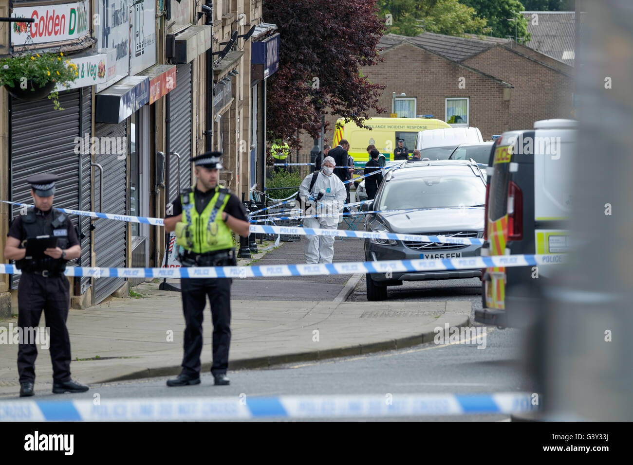 Market Street, Birstall in der Nähe von Leeds, West Yorkshire, Großbritannien. 16. Juni 2016. Im Vordergrund Offiziere Mann einen Kordon und im Hintergrund mehr Offiziere erkennbar an der Szene des Schießens wie eine Verbrechen Ermittler eine Kamera weggeht. Bildnachweis: Ian Wray Alamy Live-Nachrichten Stockfoto