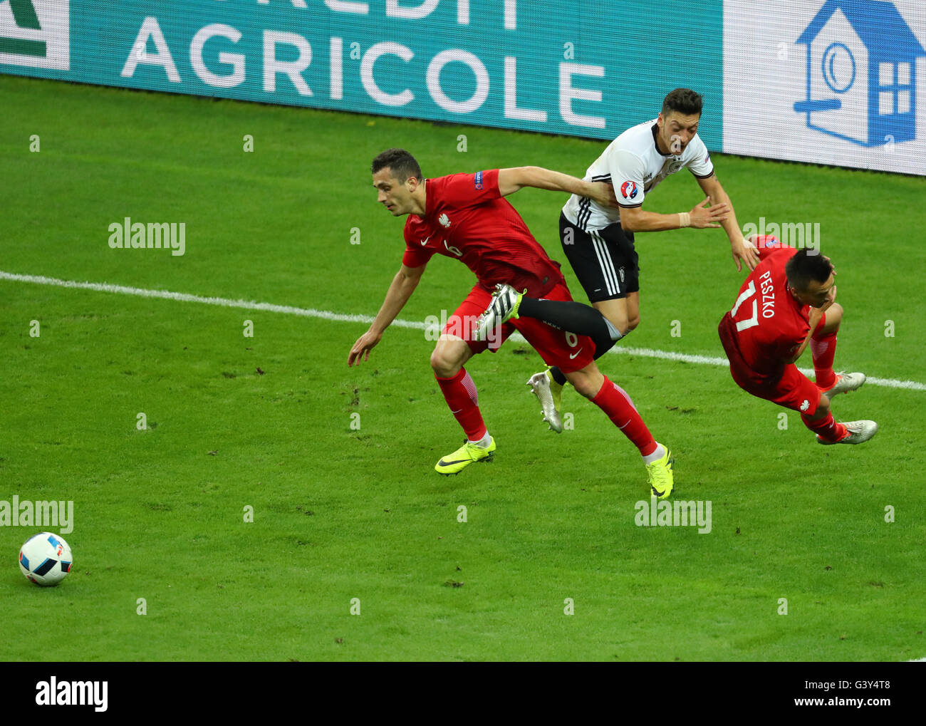 Saint-Denis, Frankreich. 16. Juni 2016. Mesut Oezil (C) Deutschland und Slawomir Peszko (R) und Tomasz Jodlowiec Polen wetteifern um die Kugel während der UEFA Euro 2016 Gruppe C Fußballspiel Deutschland und Polen im Stade de France in Saint-Denis, Frankreich, 16. Juni 2016. Foto: Christian Charisius/Dpa/Alamy Live News Stockfoto