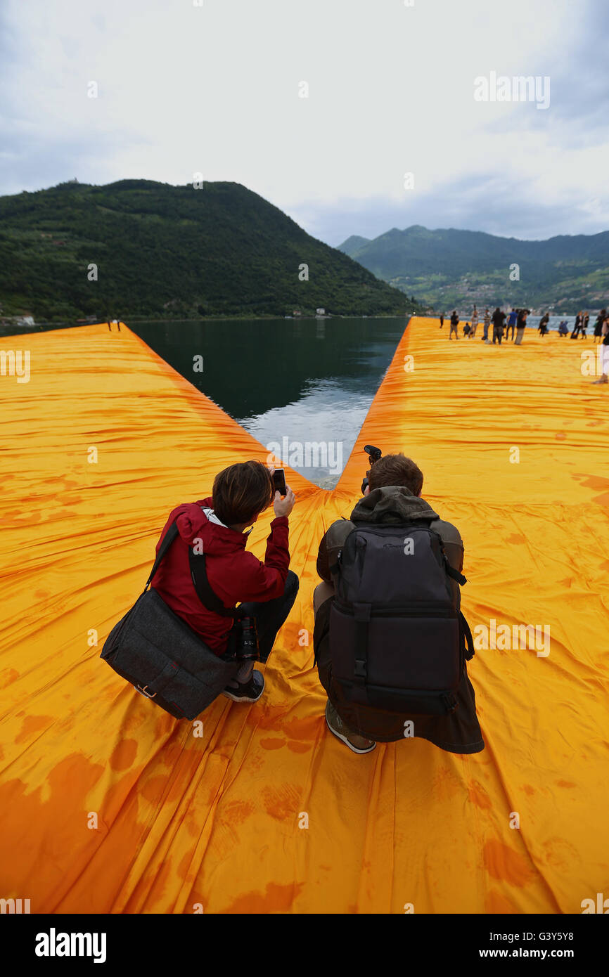 Mailand. 16. Juni 2016. Zwei Männer nehmen Sie Fotos der Installation "The Floating Piers" während einer Pressevorschau auf den Lago d ' Iseo in Oberitalien 16. Juni 2016. Das große Kunstwerk "The Floating Piers" des Künstlers Christo Vladimirov Yavachev wird vom 18. Juni bis 3 Juli für die Öffentlichkeit zugänglich. Bildnachweis: Jin Yu/Xinhua/Alamy Live-Nachrichten Stockfoto