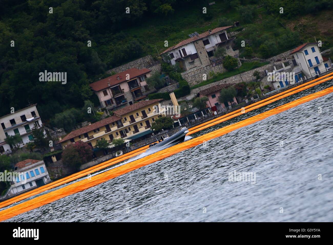 Mailand. 16. Juni 2016. Ein Boot fährt vorbei an der Installation "The Floating Piers" während einer Pressevorschau auf den Lago d ' Iseo in Oberitalien 16. Juni 2016. Das große Kunstwerk "The Floating Piers" des Künstlers Christo Vladimirov Yavachev wird vom 18. Juni bis 3 Juli für die Öffentlichkeit zugänglich. Bildnachweis: Jin Yu/Xinhua/Alamy Live-Nachrichten Stockfoto