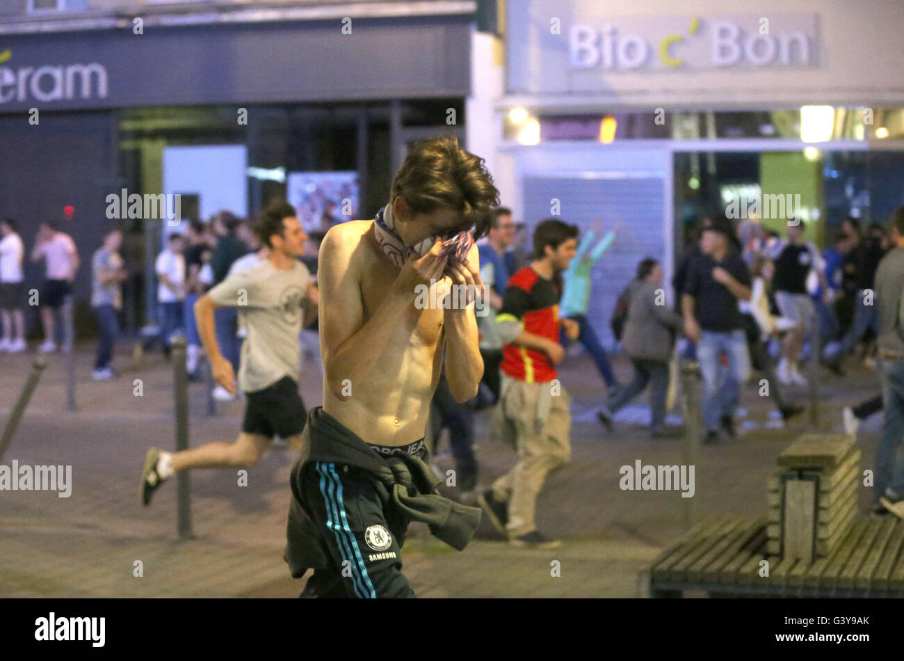 Fußball-Fans unterschiedlicher Nationalitäten und unbeteiligte versuchen, Tränengas abgefeuert von der französischen Polizei im Stadtzentrum von Lille, Frankreich, zu entkommen, wie frische Zusammenstöße zwischen England-Fans und russische Hooligans bei der Euro 2016 stattgefunden haben. Stockfoto