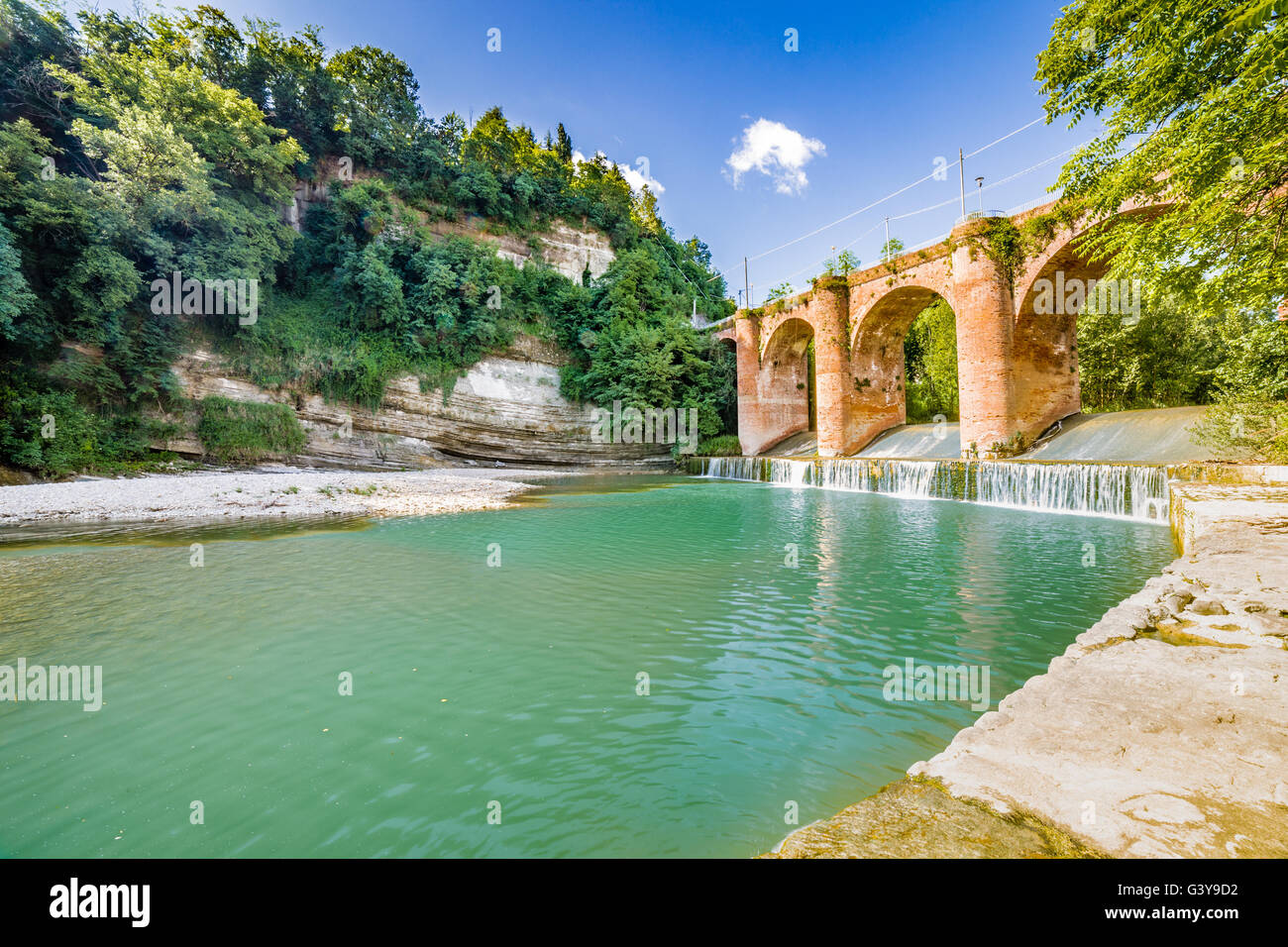 Frischen Wasser des Flusses unter vierzehnten Jahrhundert Brücke im Mauerwerk in einem kleinen Dorf in den Hügeln in Romagna, Italien Stockfoto