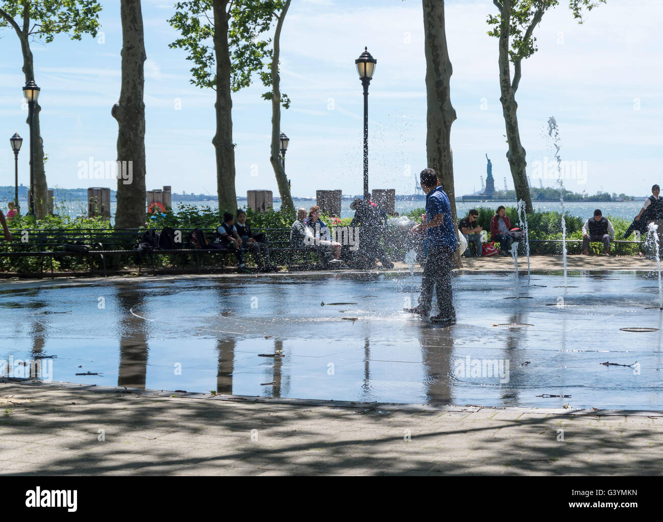 Jungs im Teenageralter läuft durch einen öffentlichen Brunnen und Flickschusterei in Battery Park, New York im Sommer kühl zu halten. Stockfoto