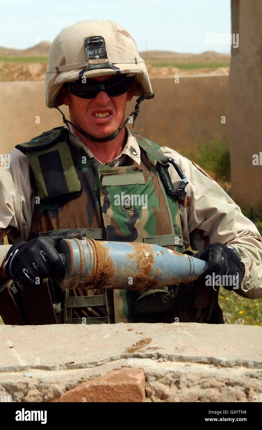 Ein Soldat trägt eine 100 Milimeter panzerbrechende Runde. Stockfoto