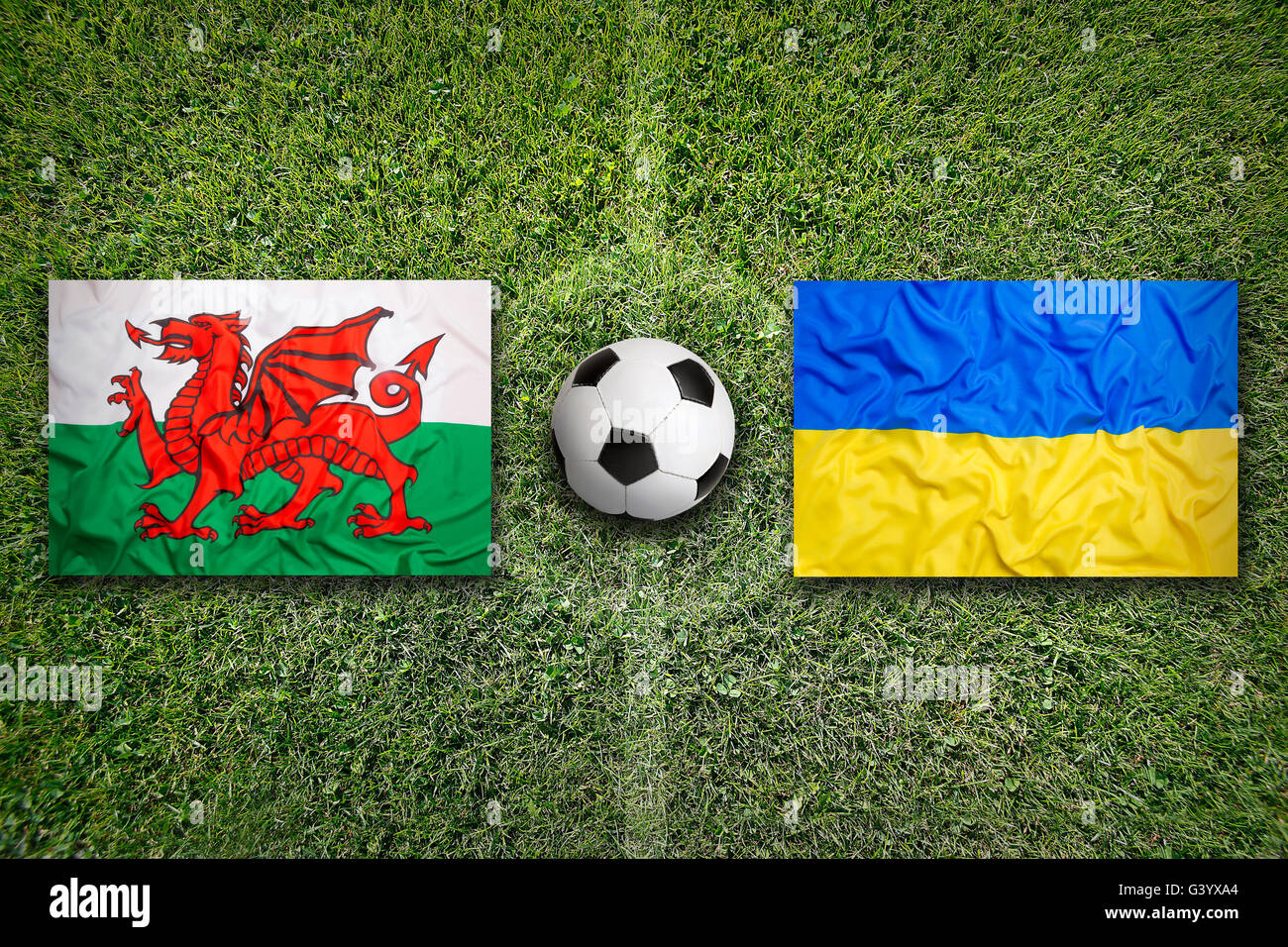 Wales vs. Ukraine Fahnen auf grüne Fußballplatz Stockfoto