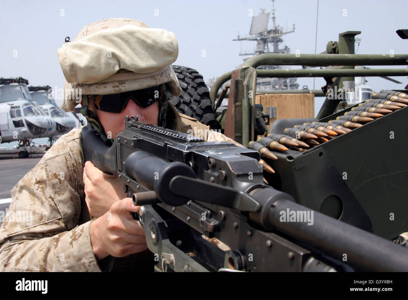 Eine Marine scannt den Horizont über die Websites von seinem Maschinengewehr M240G Medium. Stockfoto