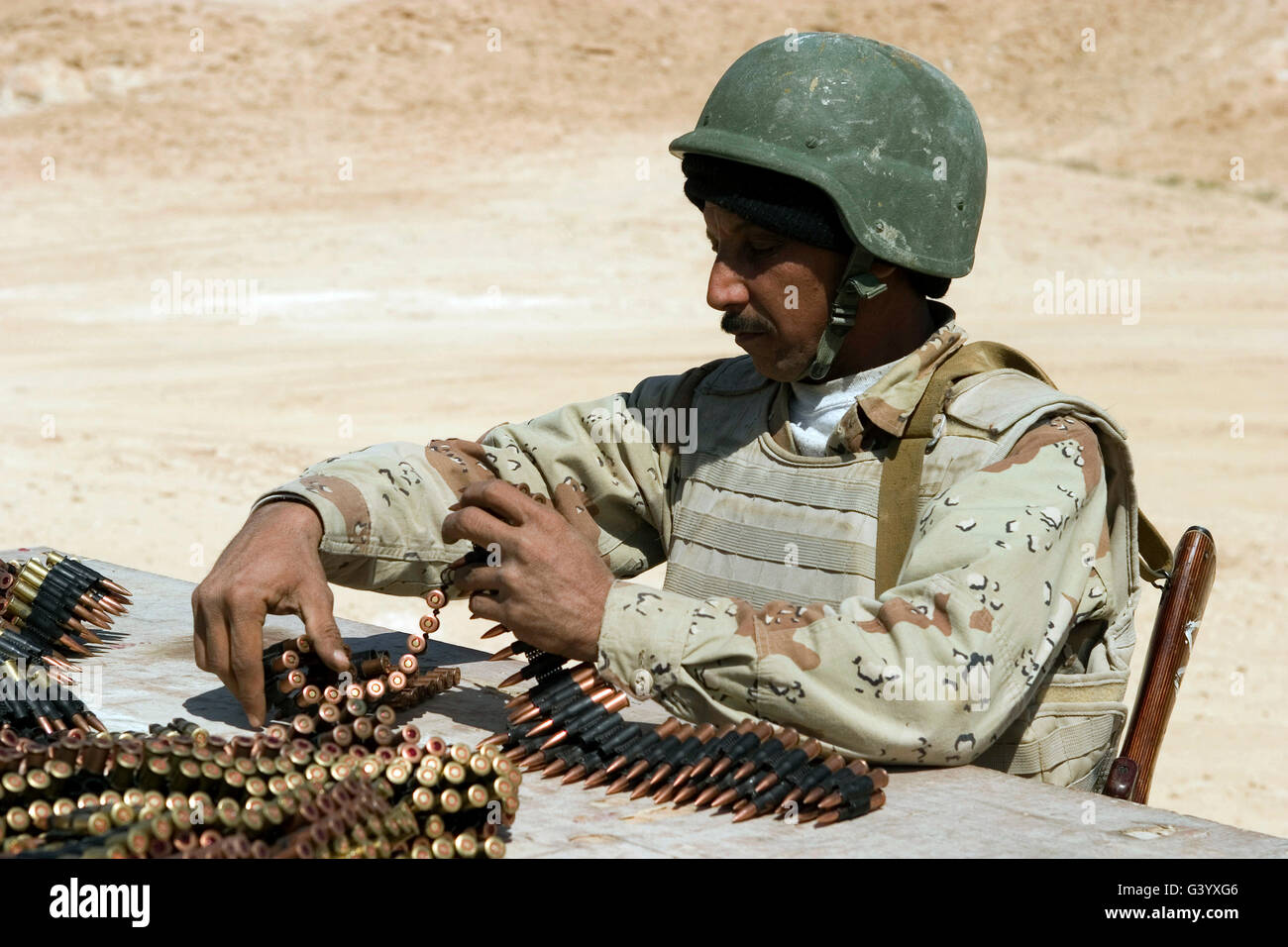 Ein Soldat der irakischen Armee bereitet Gürtel von Munition für seine PKM 7,62-mm-Maschinengewehr. Stockfoto