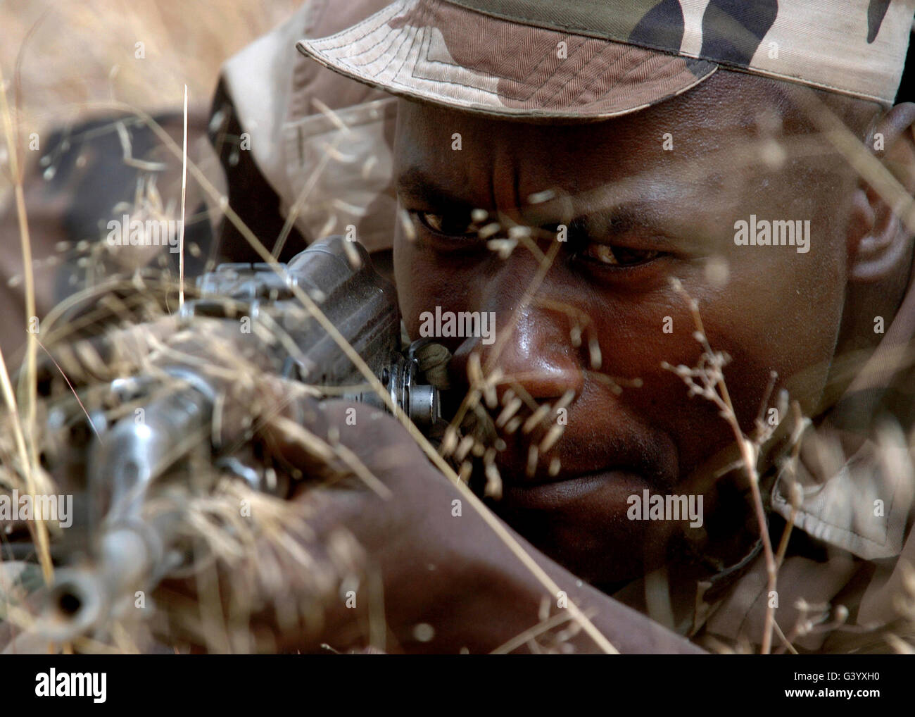 Ein nigerianischer Soldat simuliert Festlegung Schüsse während Kampftraining zu unterdrücken. Stockfoto