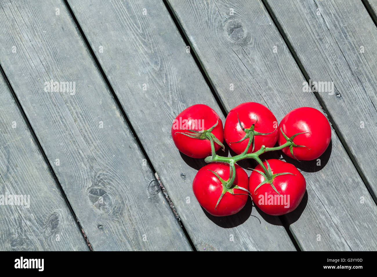 Fünf rote Tomaten in Olympischen Ringen Form im Holz Hintergrund Stock Stockfoto
