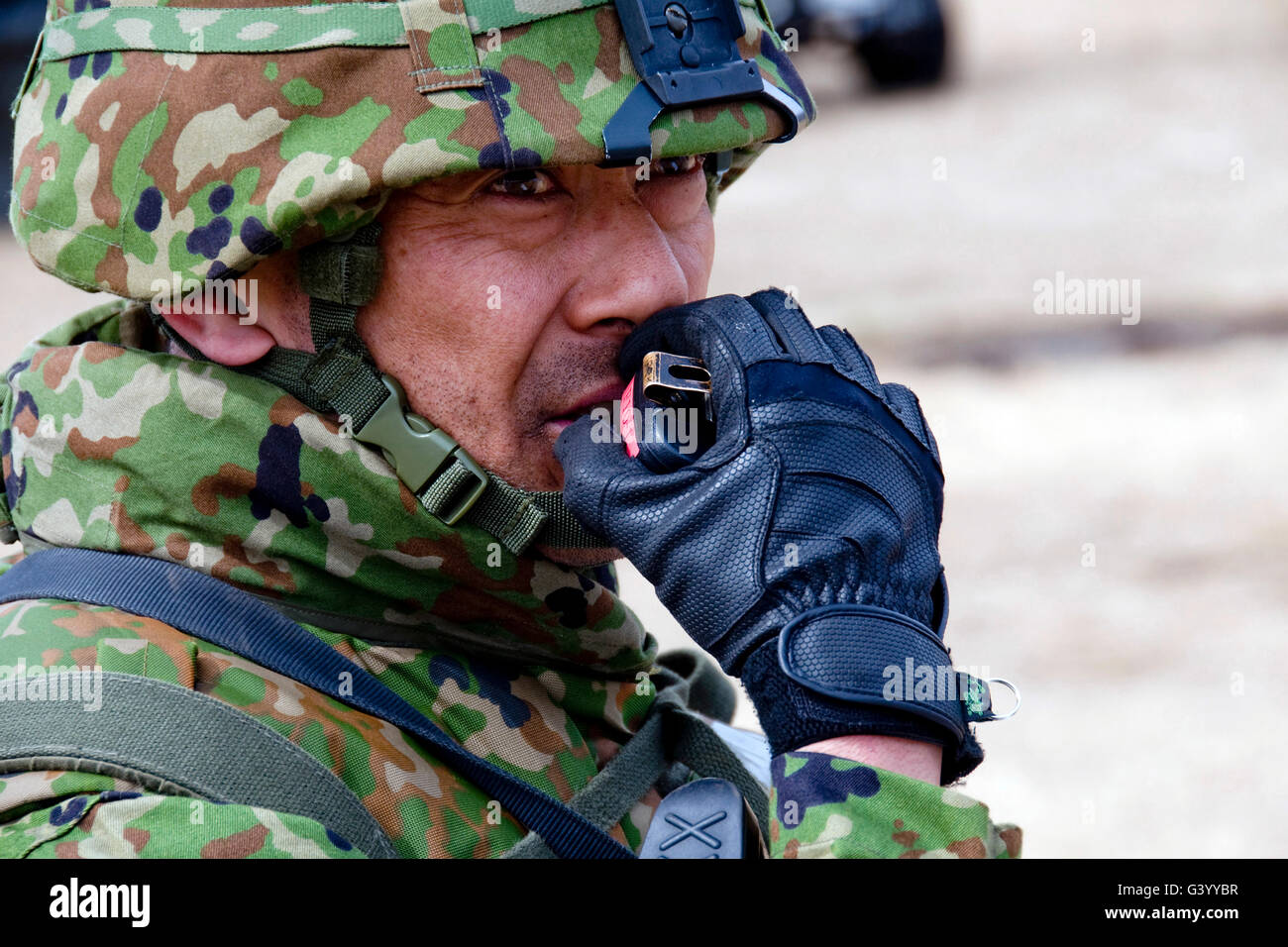 Mitglied der Japan Ground Self-Defense Force Relais Anweisungen an seine Truppen über ein Radio. Stockfoto