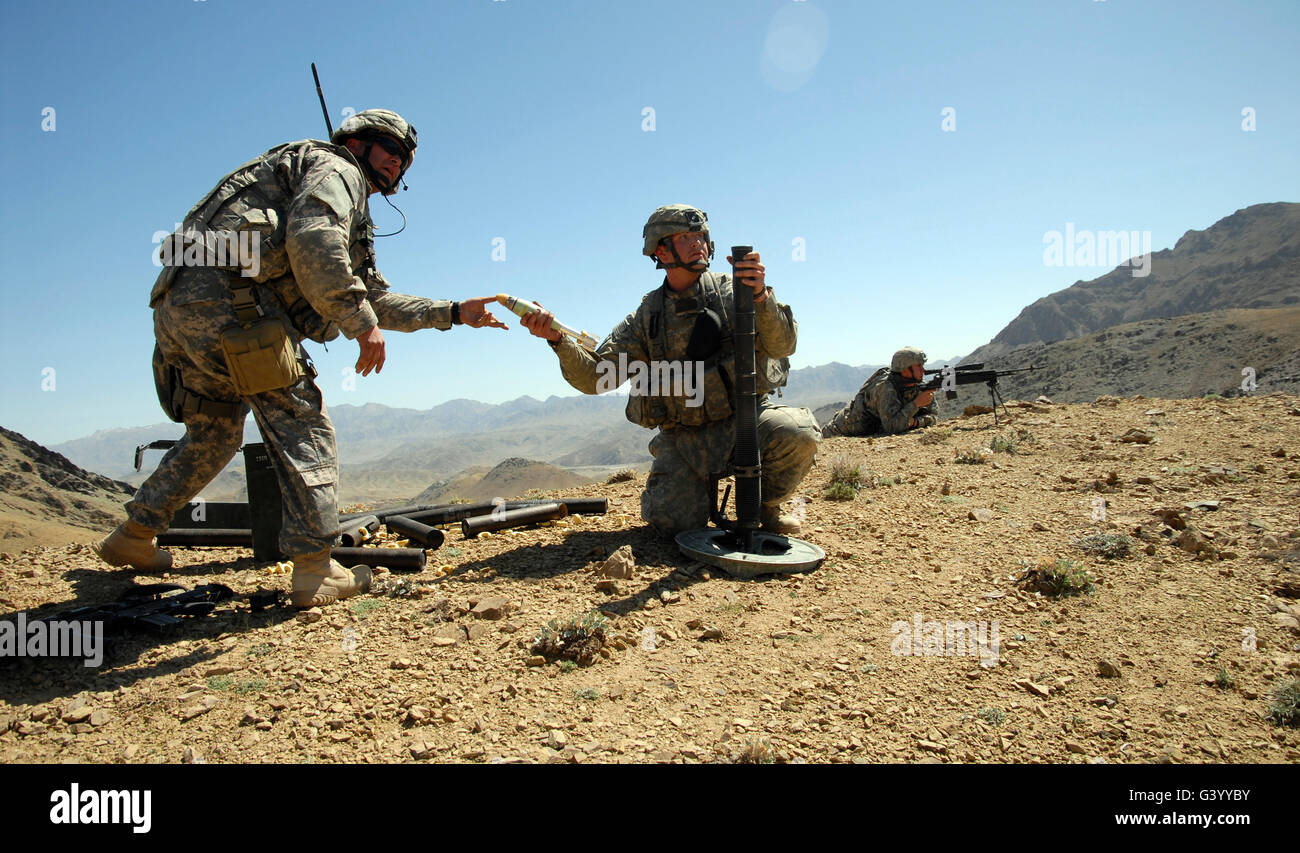 US Army Soldat Hände ein 60 mm Mörser Runden auf einem Kameraden gleichzeitig Feuerunterstützung auf feindliche Stellungen. Stockfoto