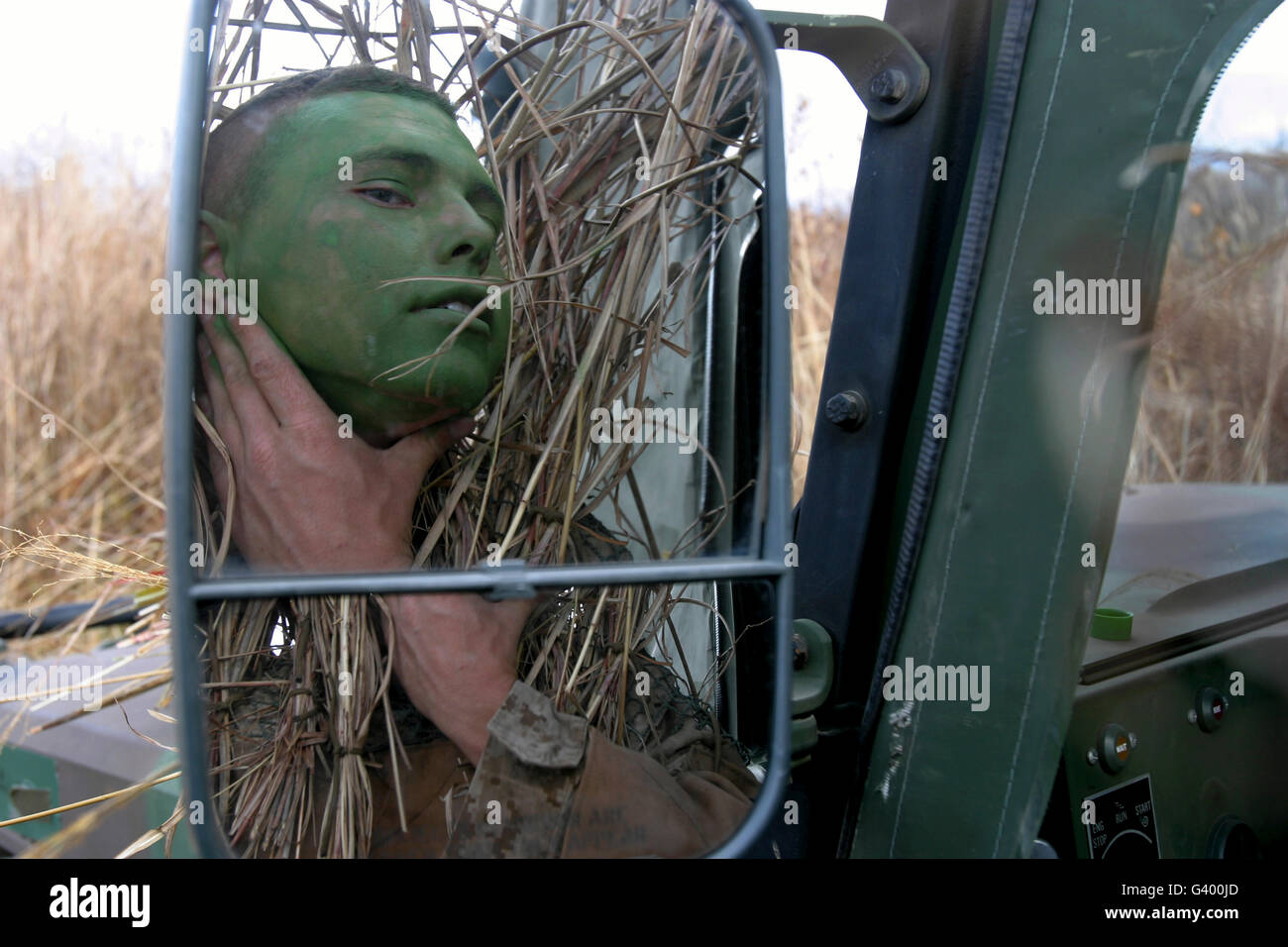 Ein Scout Beobachter gilt Tarnung Farbe nach seinem selbstgemachten Ghillie-Anzug anziehen. Stockfoto