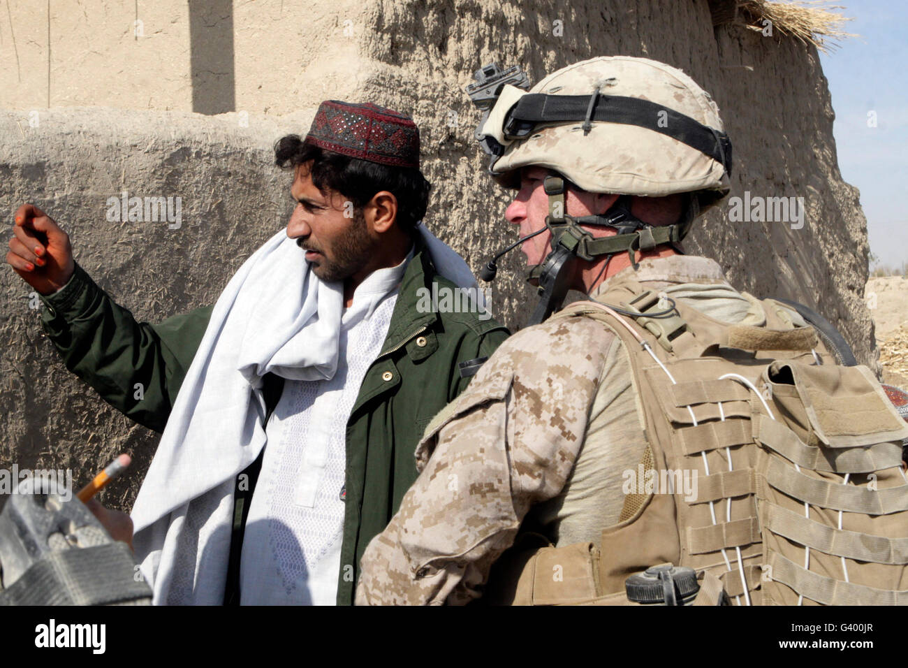 Ein Soldat im Gespräch mit einem lokalen Dorfbewohner während einer Patrouille in Afghanistan. Stockfoto