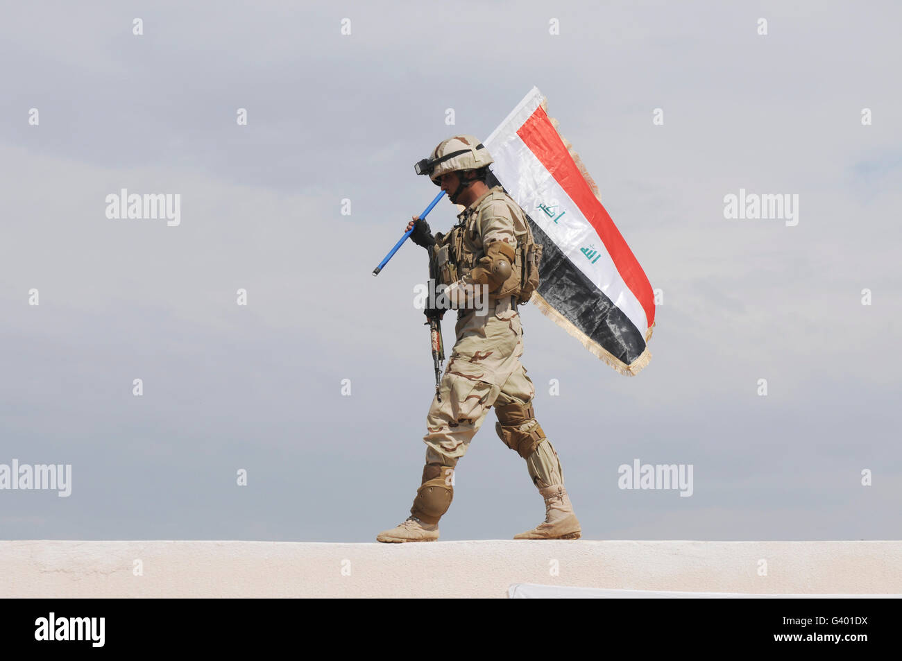 Ein irakischer Soldat trägt die irakische Flagge. Stockfoto