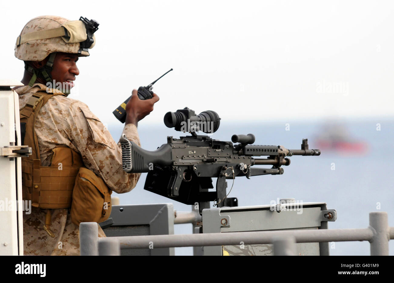 US-Marine Gespräche über ein Radio während der Besatzung eines M-240B-Maschinengewehr. Stockfoto