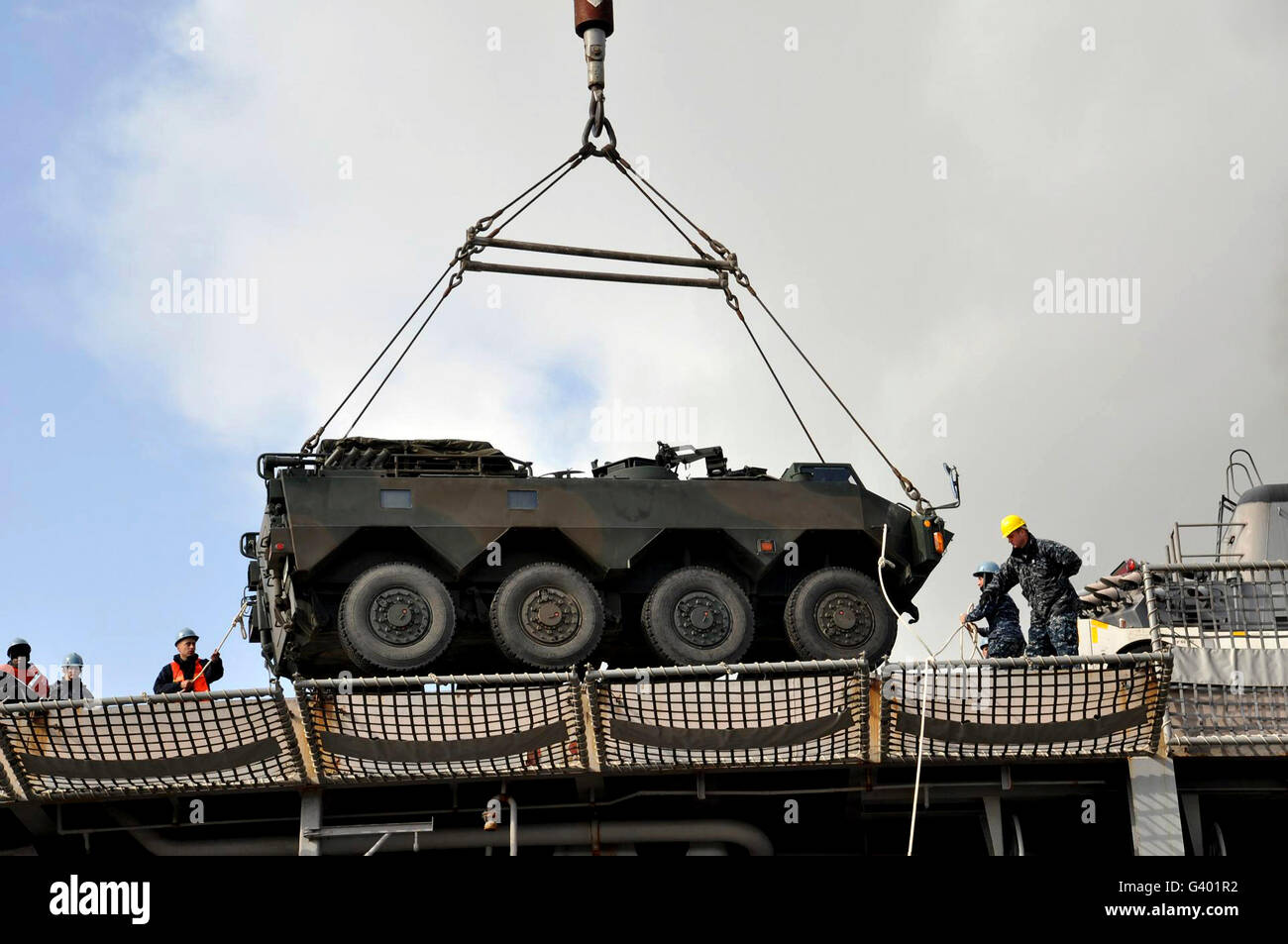 Decksbereich Mitglieder laden einen japanischen gepanzerten Lastwagen auf USS Tortuga. Stockfoto