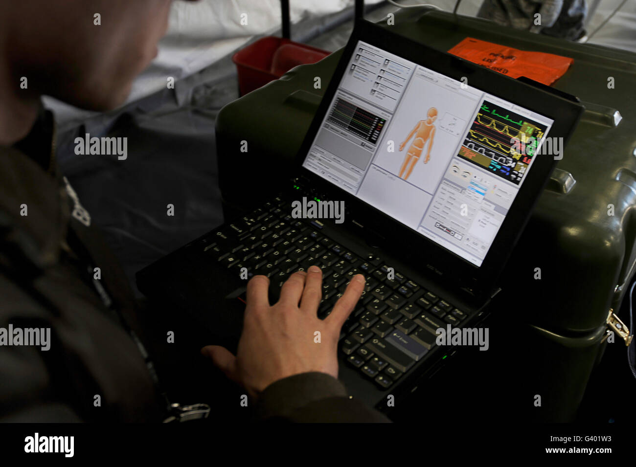 Ein US-Flieger blickt auf einen Laptop zu helfen medizinische Hilfe leisten. Stockfoto