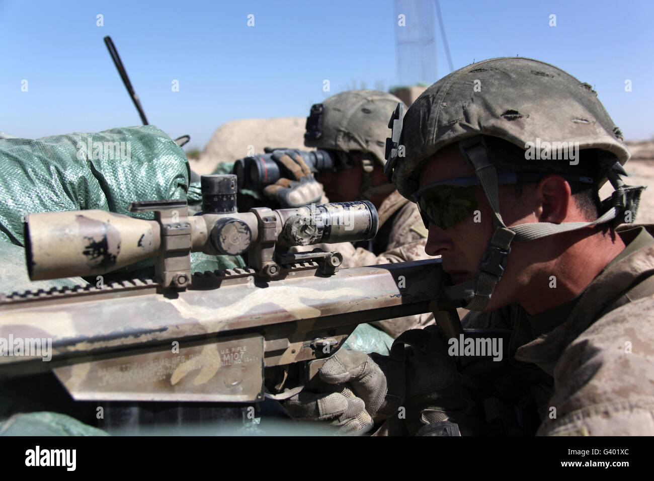 Zwei Scharfschützen bieten Overwatch als einen Kader von US-Marines Auszug aus ihrer Patrouille-Basis. Stockfoto