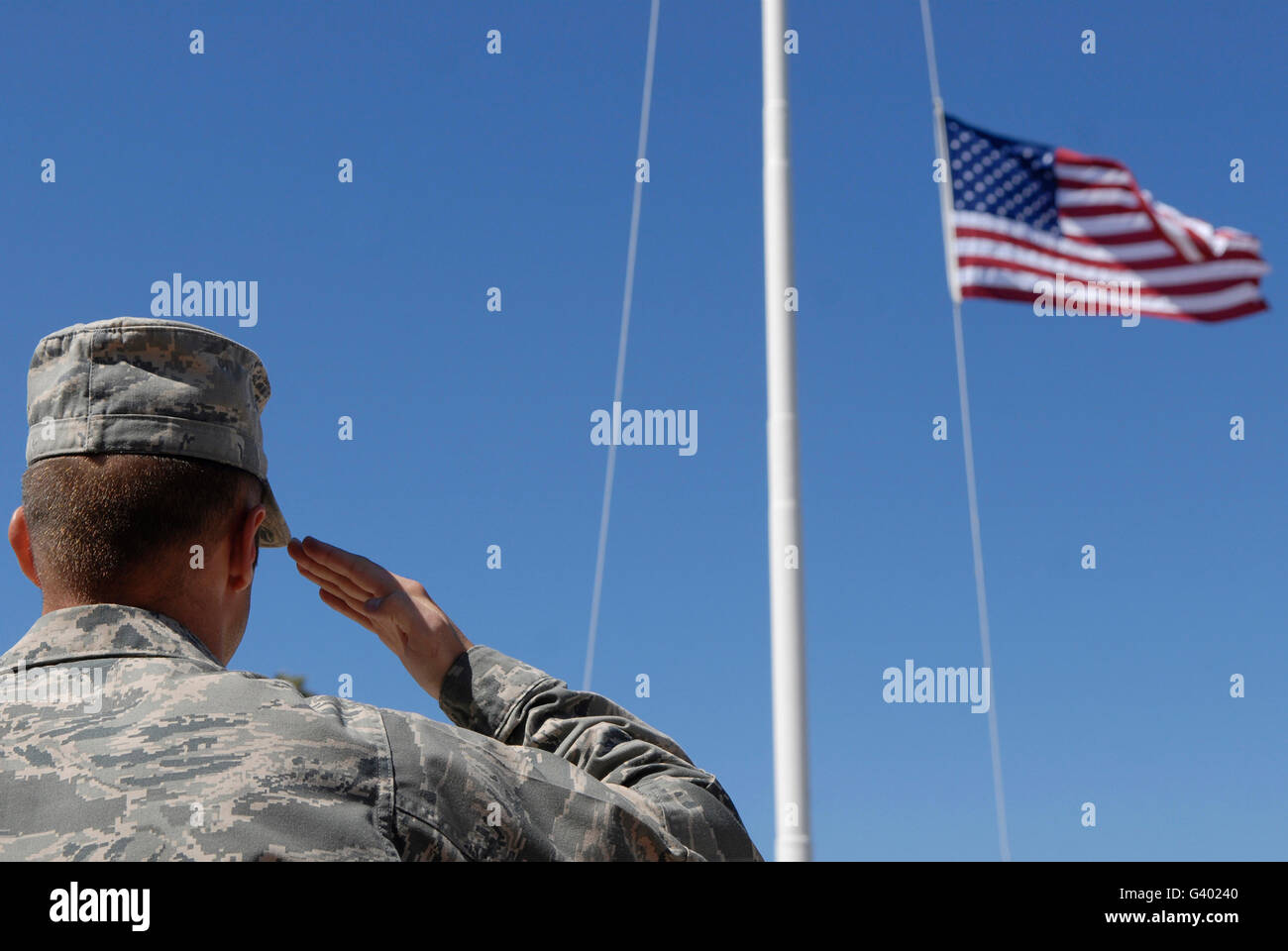 Ein Soldat grüßt die amerikanische Flagge. Stockfoto