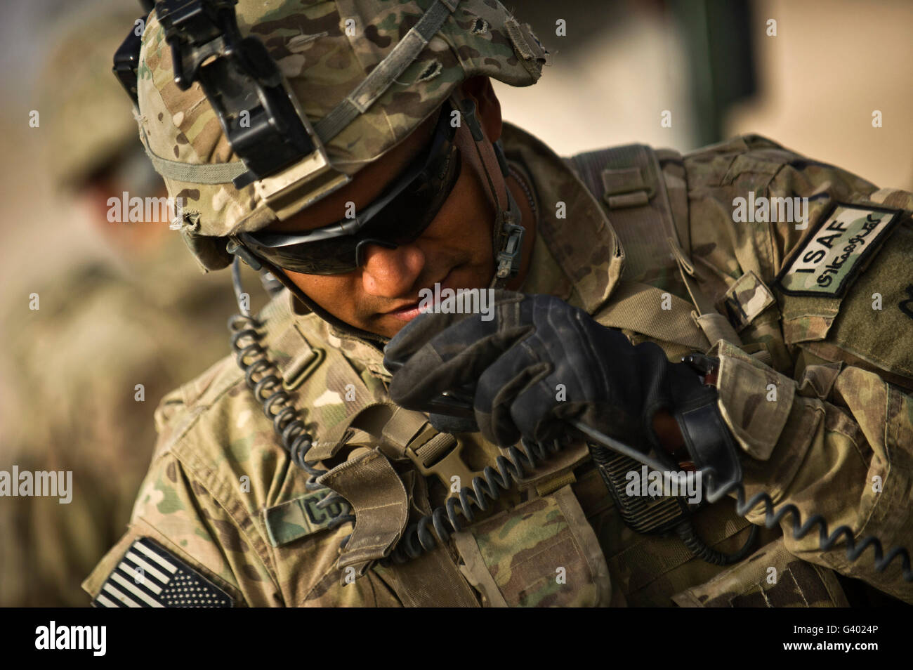 US Army Soldat kommuniziert mit seiner Crew auf seinem Radio. Stockfoto