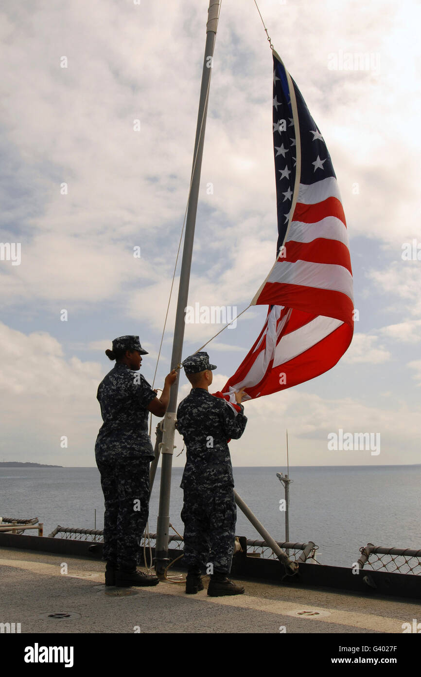 Matrosen erhöhen die amerikanische Flagge an Bord der USS Tortuga. Stockfoto