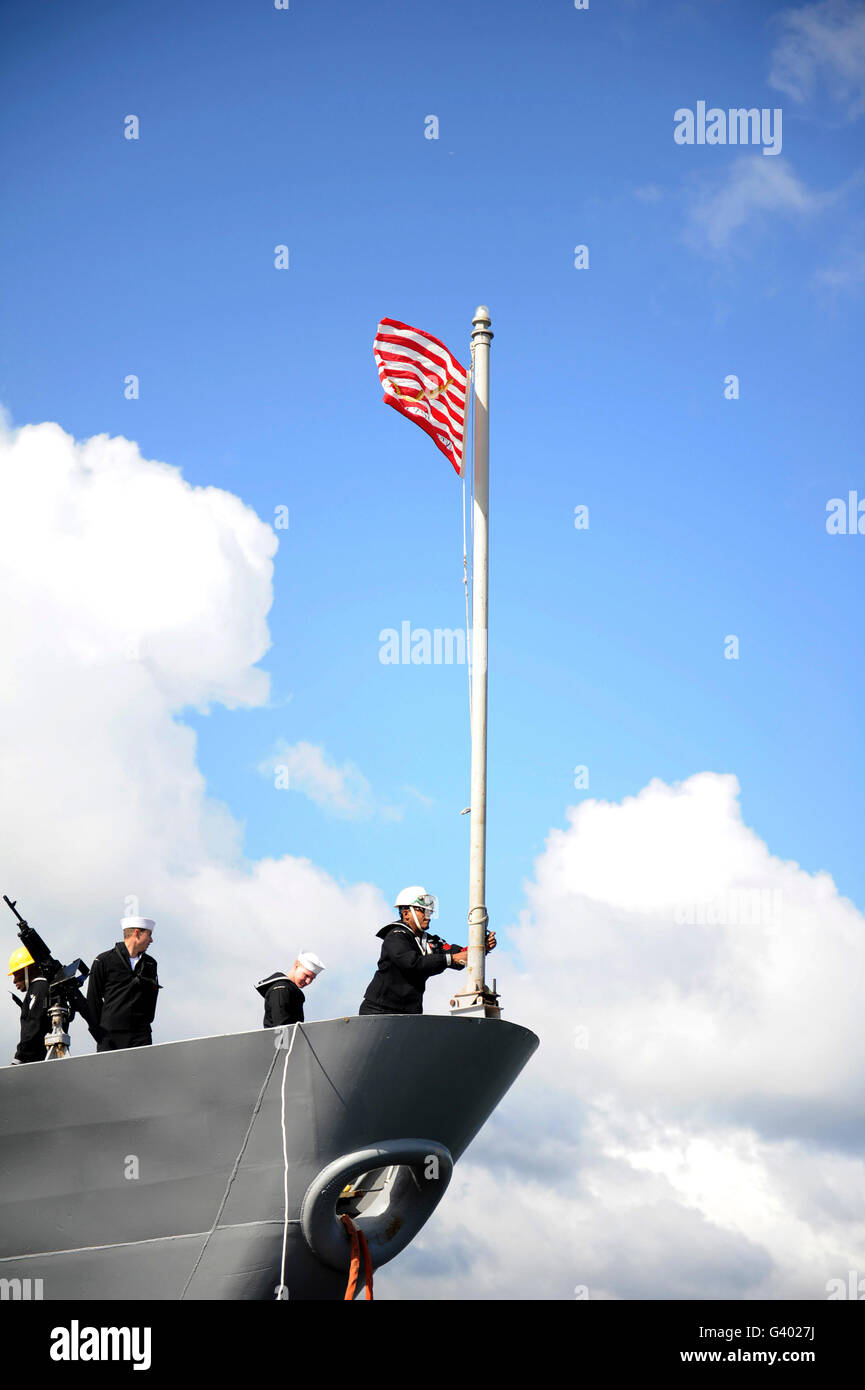 Ein Seemann wirft die erste Marine-Buchse an den Fahnenmast der USS Monterey. Stockfoto