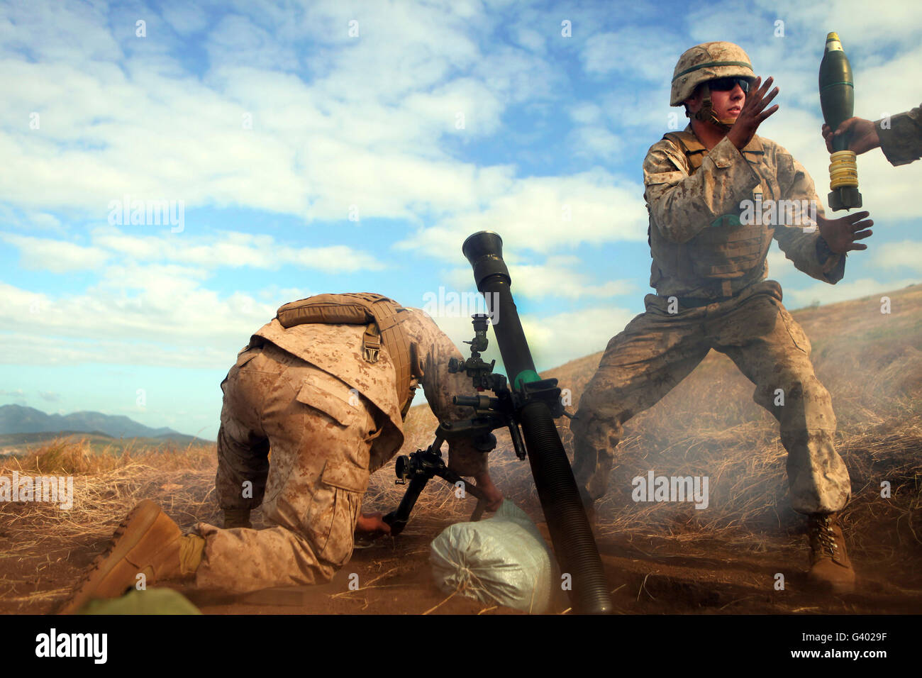 US-Marine hält einen Mörtel Schlauch ruhig wie Kollege Marine schnappt sich ein anderer Mörtel Runde. Stockfoto