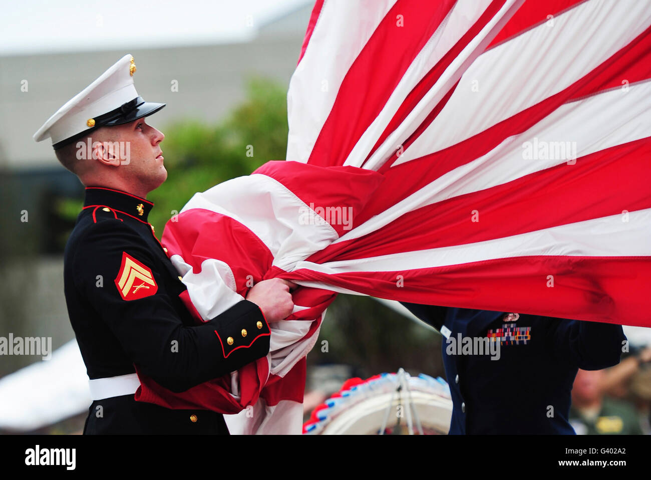 Ein United States Marine nimmt die amerikanische Flagge in die Hände vor dem zusammenklappen es. Stockfoto