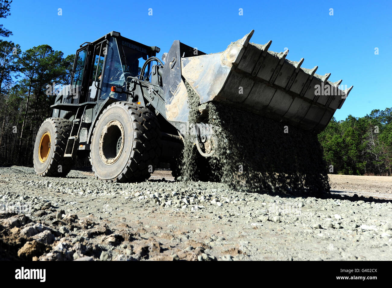 Ein front-End-Loader Anhebung ein Straße-Bett auf Camp Johnson. Stockfoto