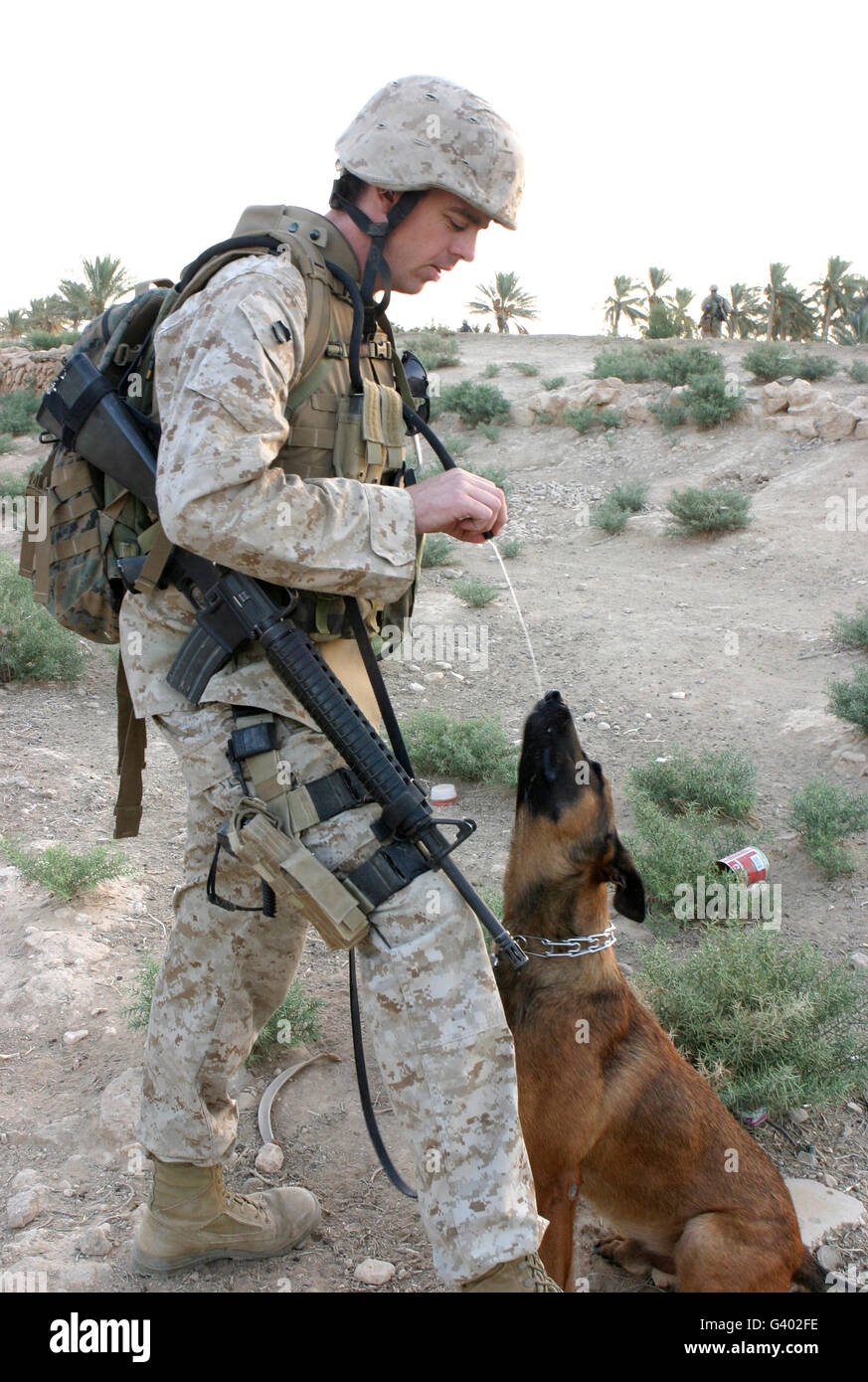 Ein Soldat und seine Suchhund nehmen eine Trinkpause. Stockfoto