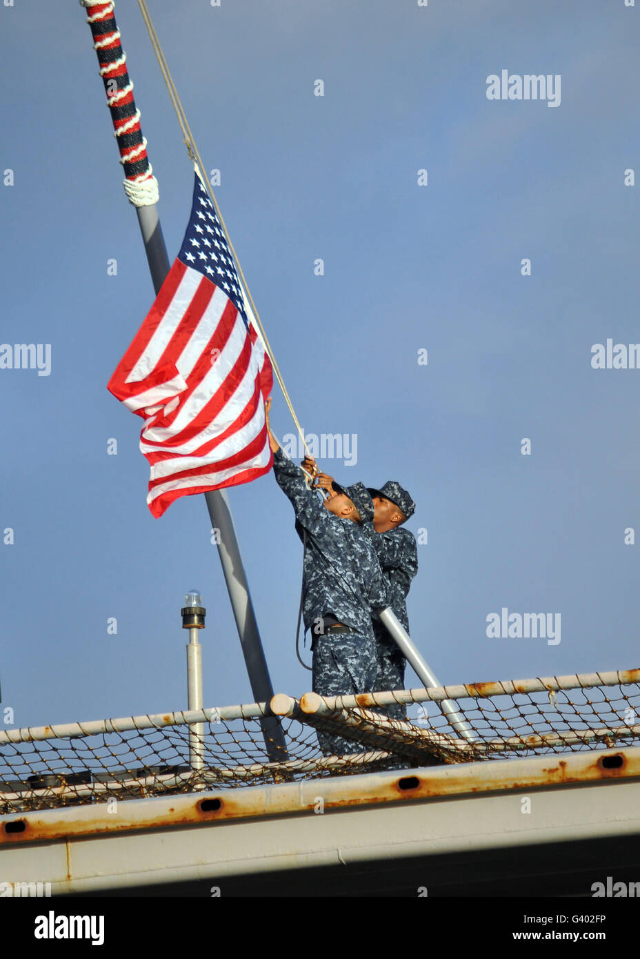 Matrosen senken der nationalen Fähnrich an Bord der USS Ponce. Stockfoto