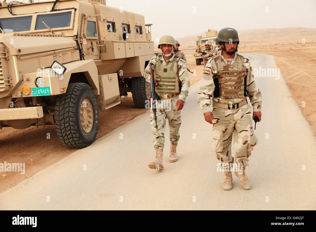 Soldaten der irakischen Armee Fuß neben einem MRAP Fahrzeug im Irak. Stockfoto