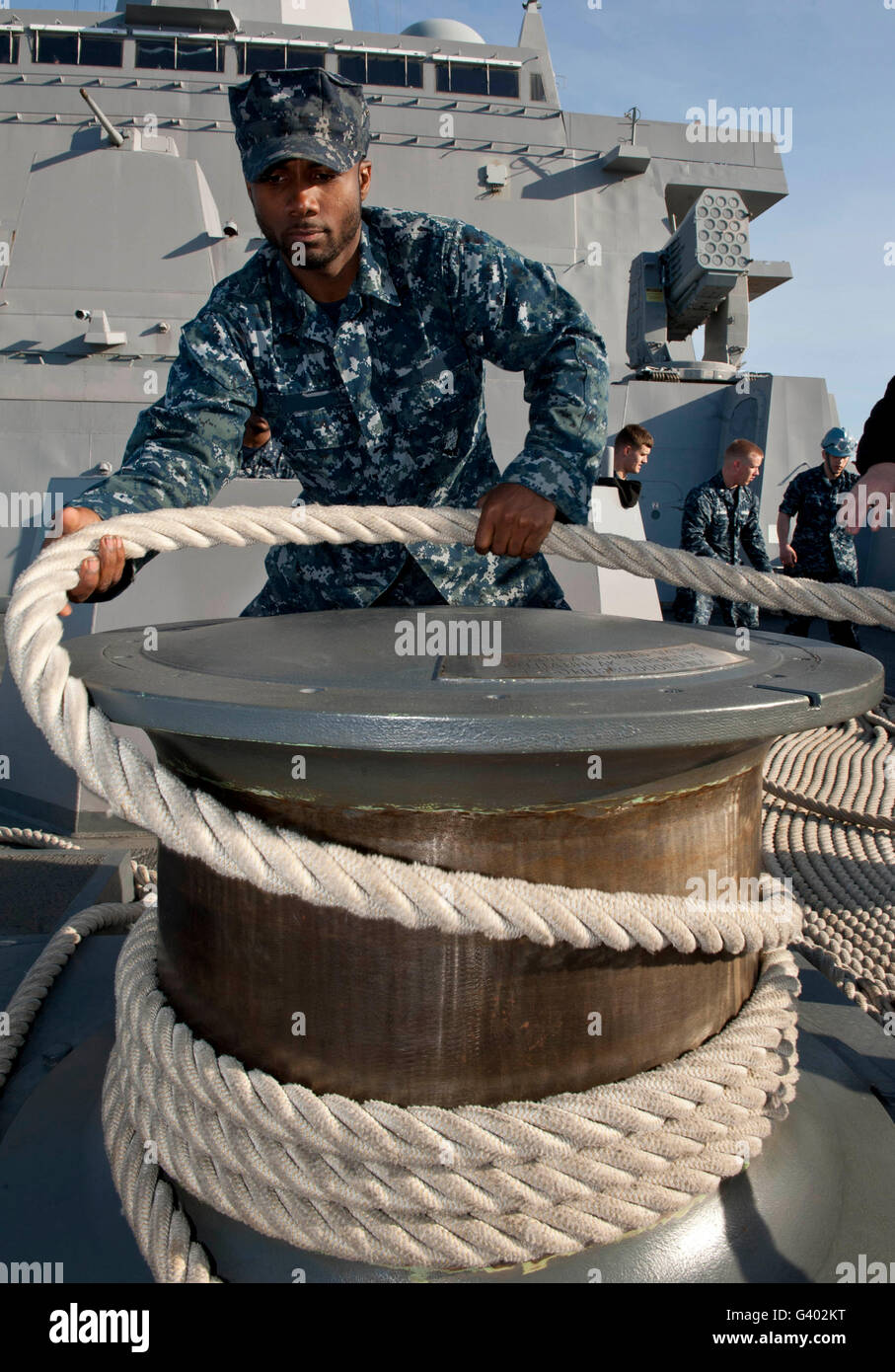 Seemann läuft eine Befestigungsleine um ein Capstan an Bord der USS New York. Stockfoto