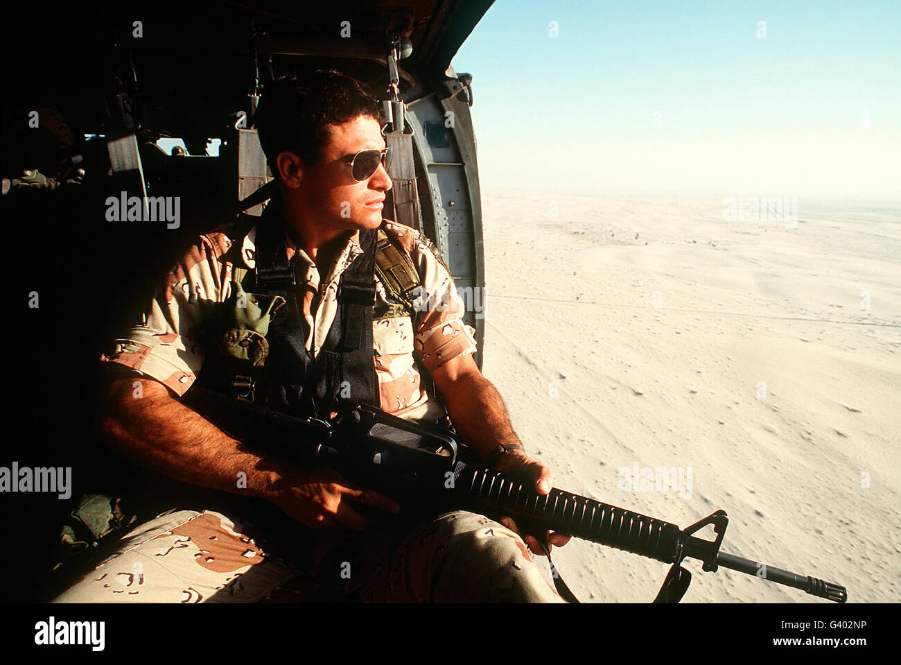Ein Soldat scannt den Horizont von innen ein Hubschrauber während der Operation Desert Storm. Stockfoto