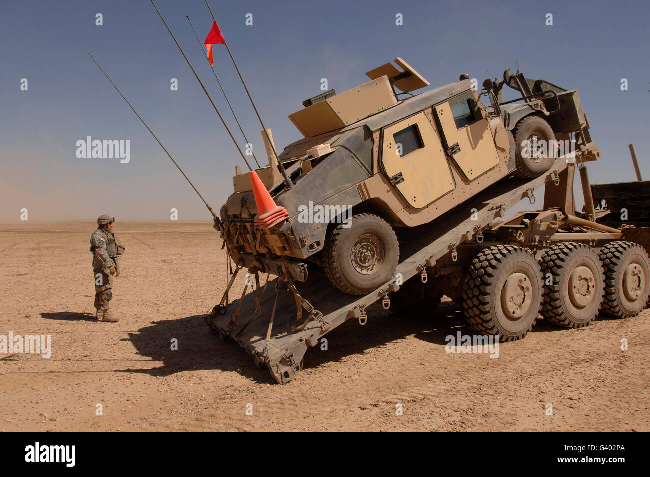 Ein M1114 gepanzertes Fahrzeug wird aus Heavy Equipment Transporter entfernt. Stockfoto