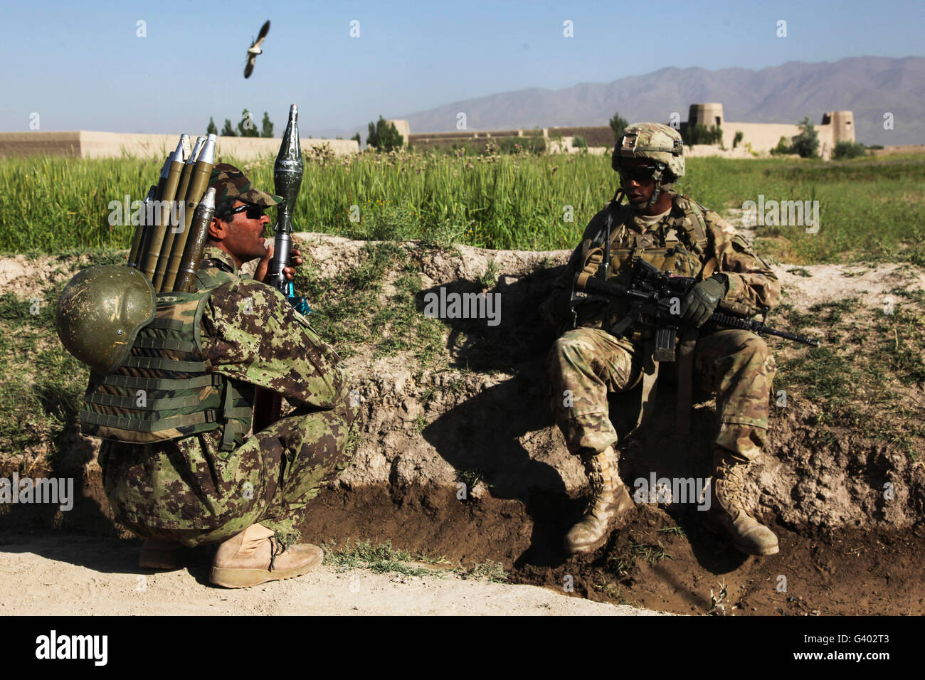 Soldat der US-Armee nimmt sich eine Auszeit mit einem Afghan National Army Soldaten. Stockfoto