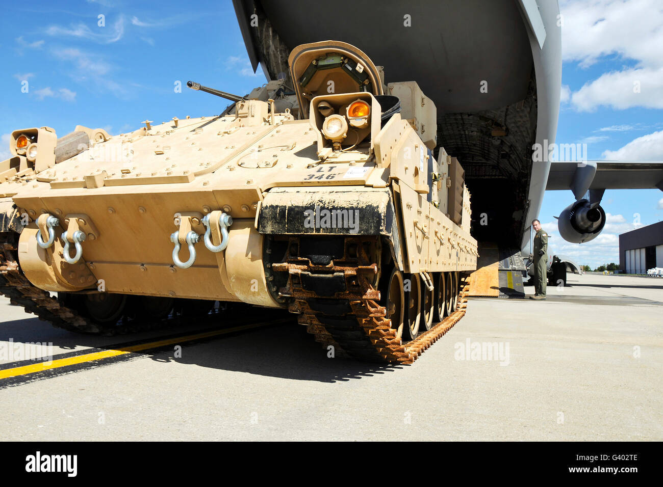 Ein M2/M3 Bradley Kampffahrzeug fährt in Richtung einer c-17-Laderaum. Stockfoto
