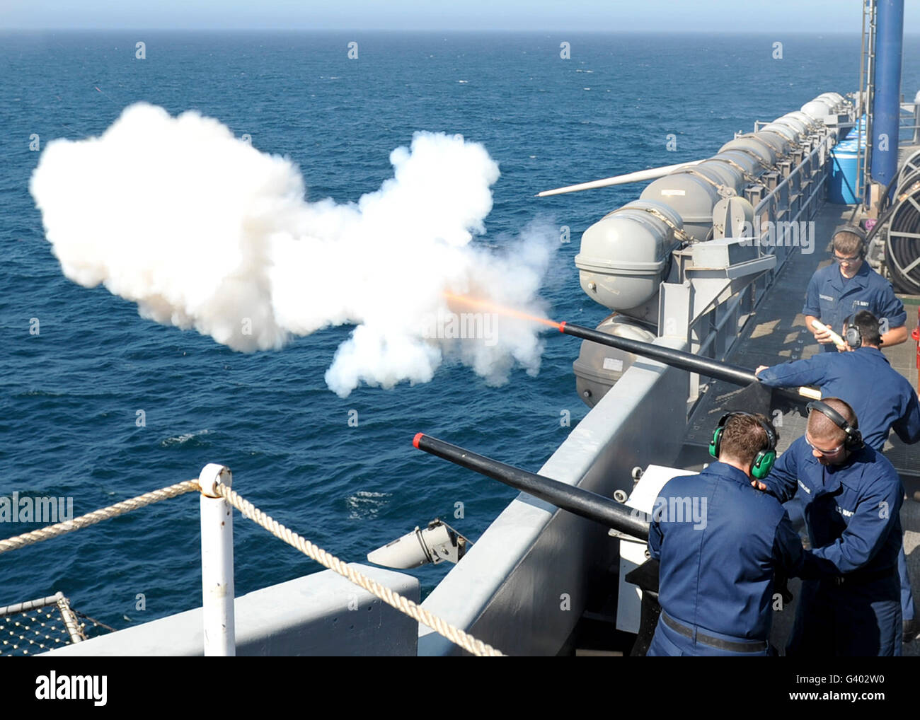 Gunners Verknüpfungen testen Feuer, das des Schiffs salutieren an Bord der USS Nimitz Kanonen. Stockfoto