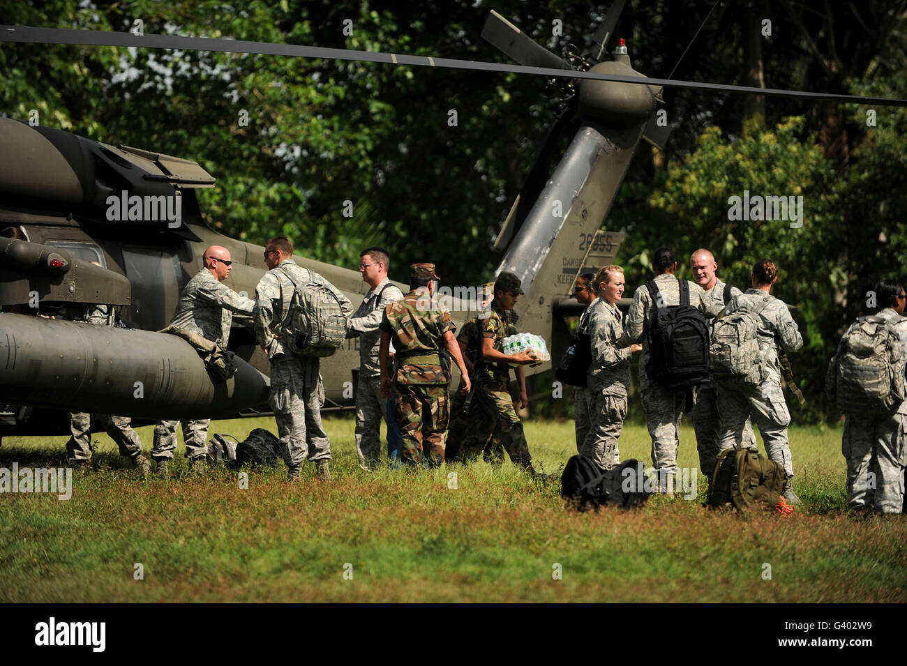 Soldaten zu entladen medizinische Versorgung, Nahrung und Wasser von einem UH-60 Blackhawk. Stockfoto