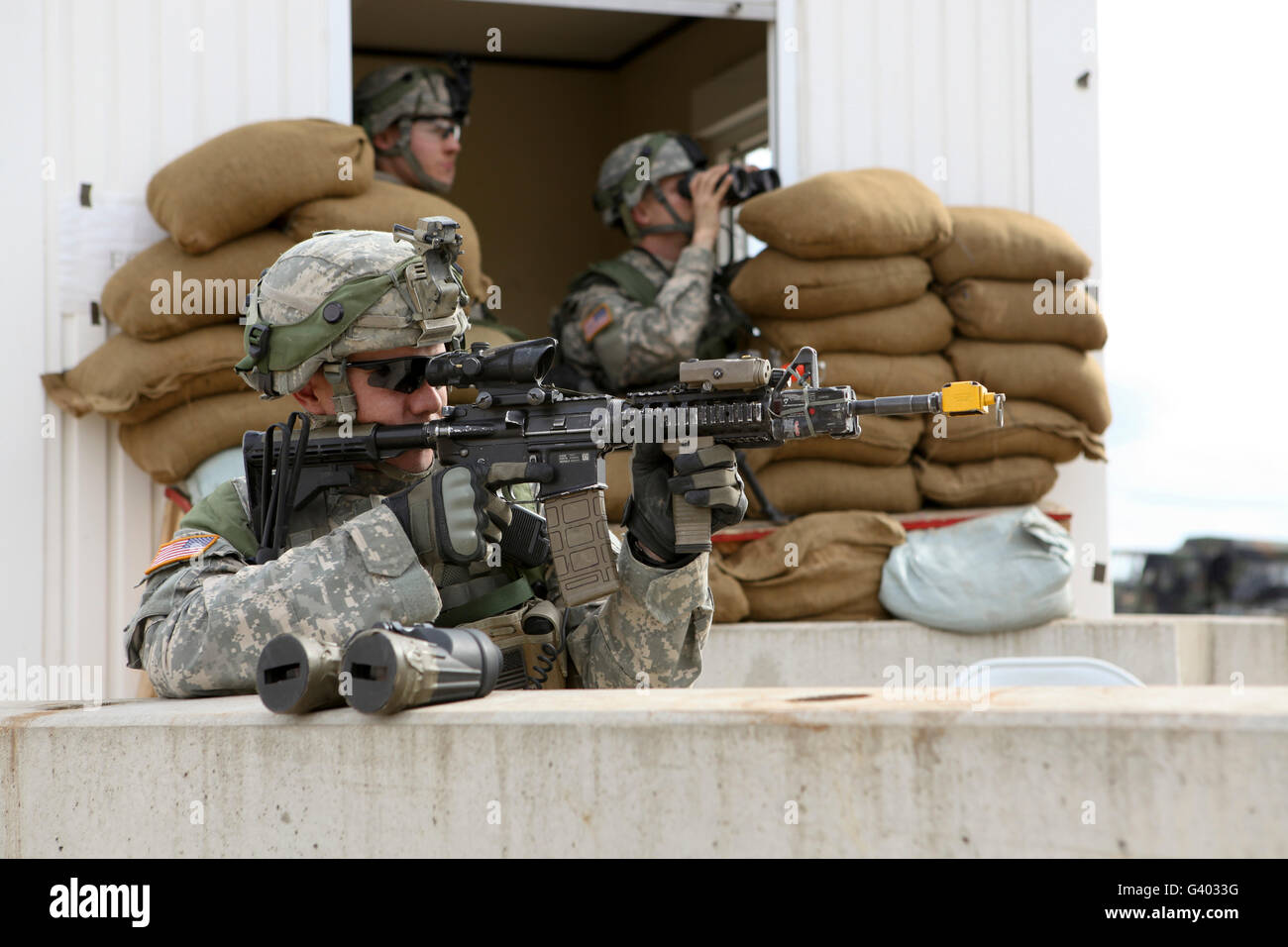 US Army Soldat schaut den Anwendungsbereich seiner M4-Sturmgewehr. Stockfoto