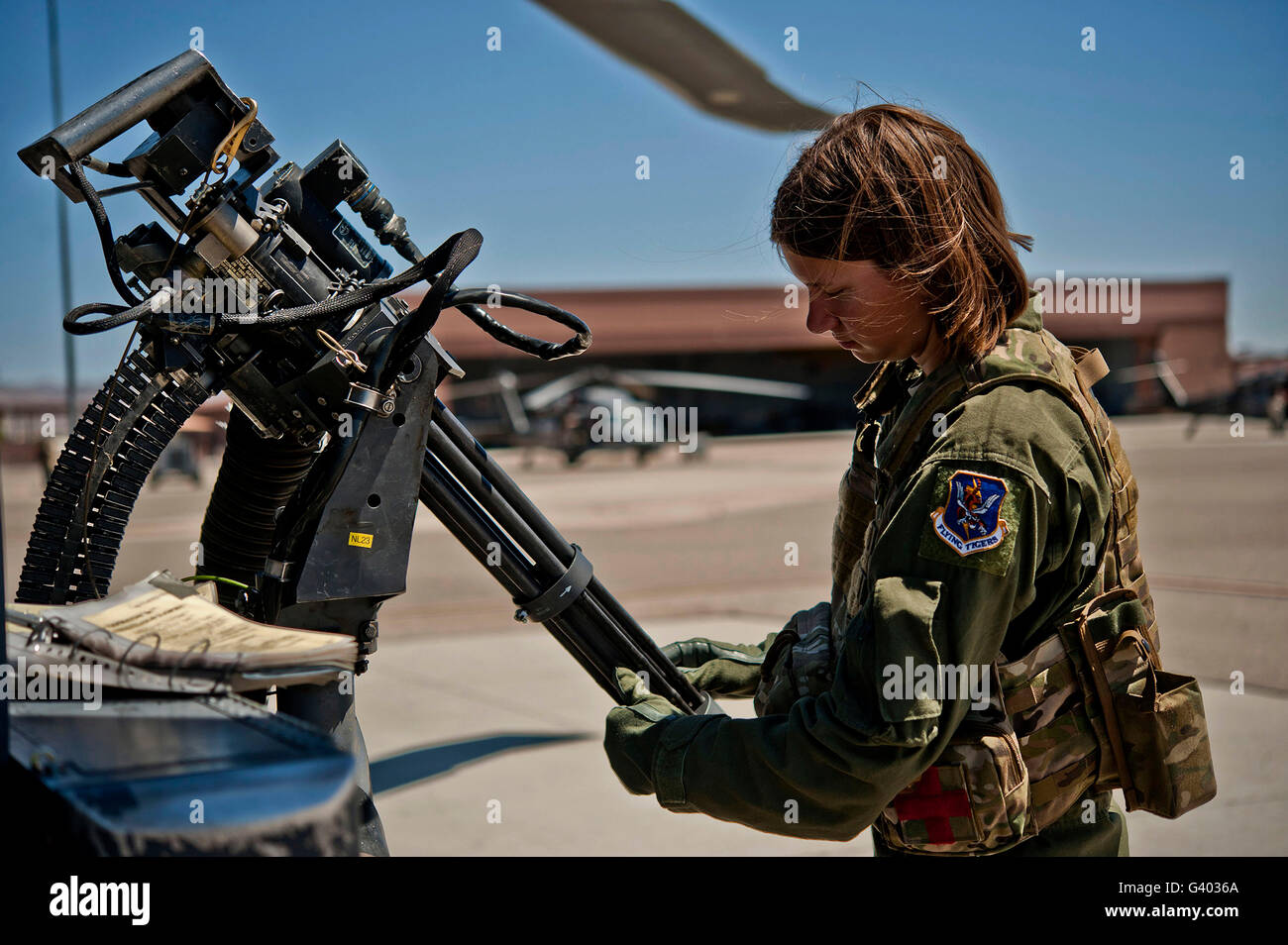 Airman untersucht die Fässer mit einem GAU-2 Mini-Pistole auf ein HH-60 Pave Hawk. Stockfoto